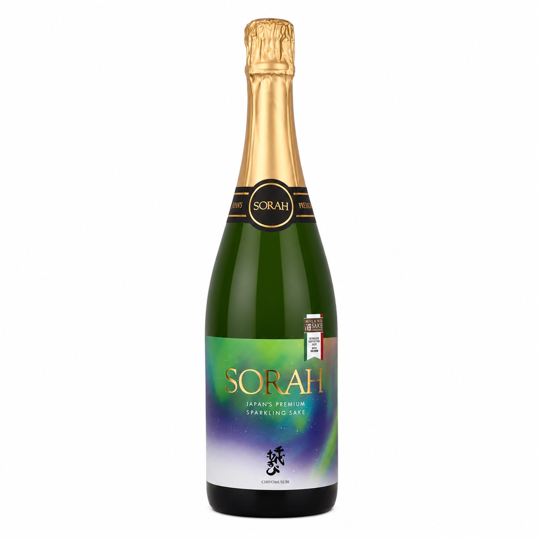 A bottle of Sorah Sparkling sake on a plain white background. The bottle is dark green glass with a gold foil top and a colorful label featuring green, yellow, and purple hues with gold lettering.